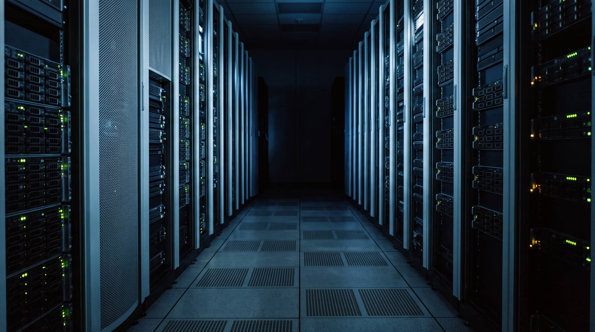 A data-center cold aisle between rows of server racks.